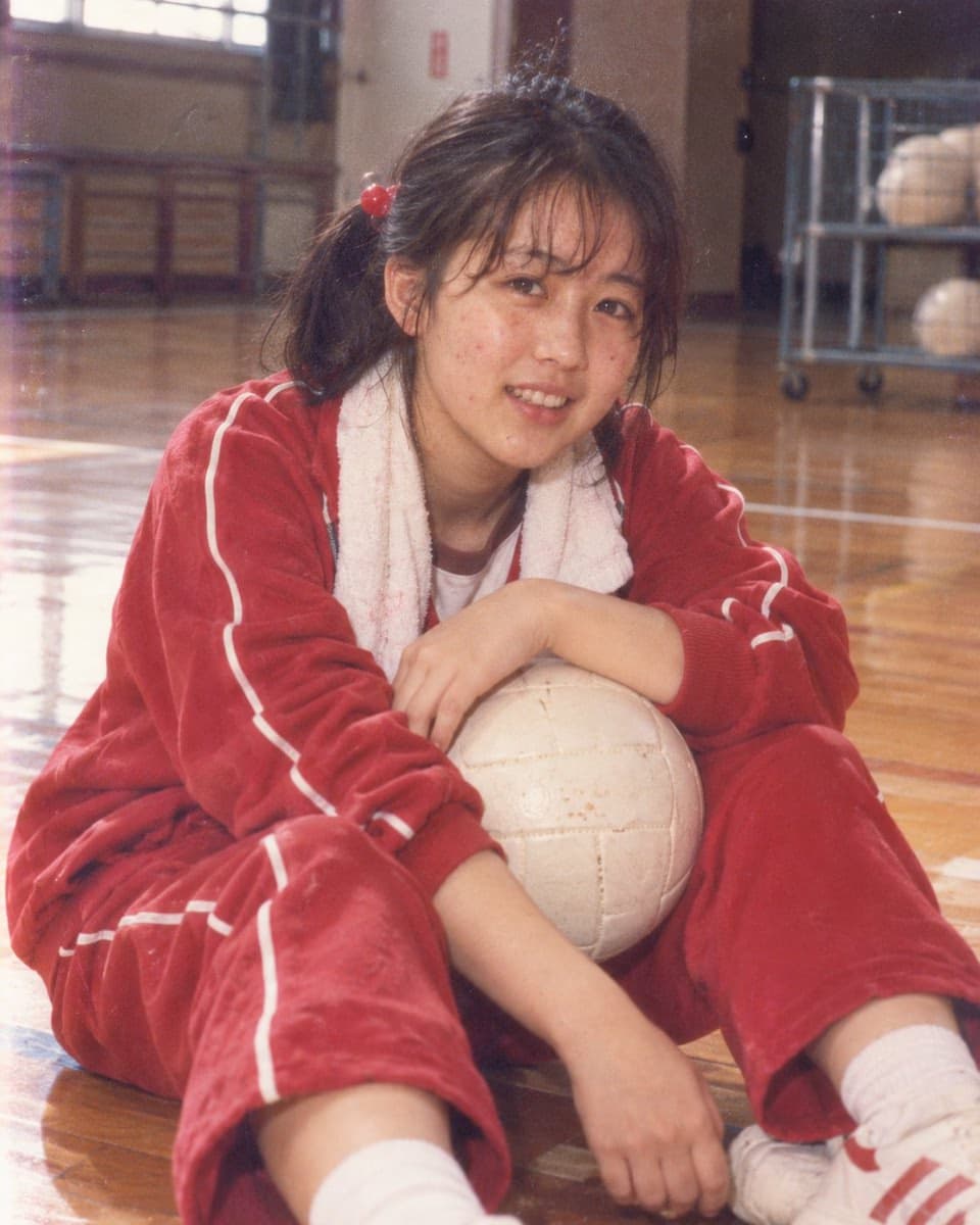 Nostalgic girl with volleyball in gymnasium